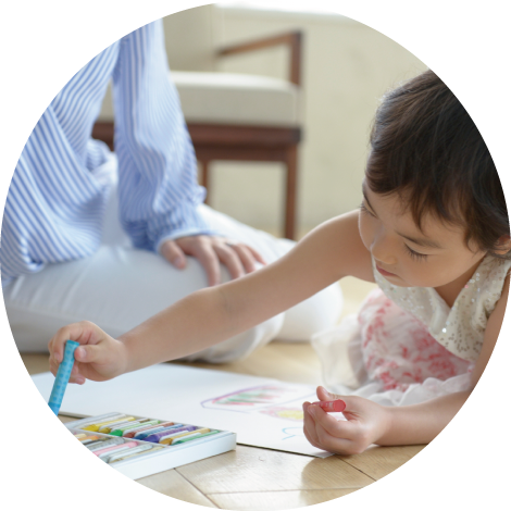 絵を描いている女の子と見守るお母さん